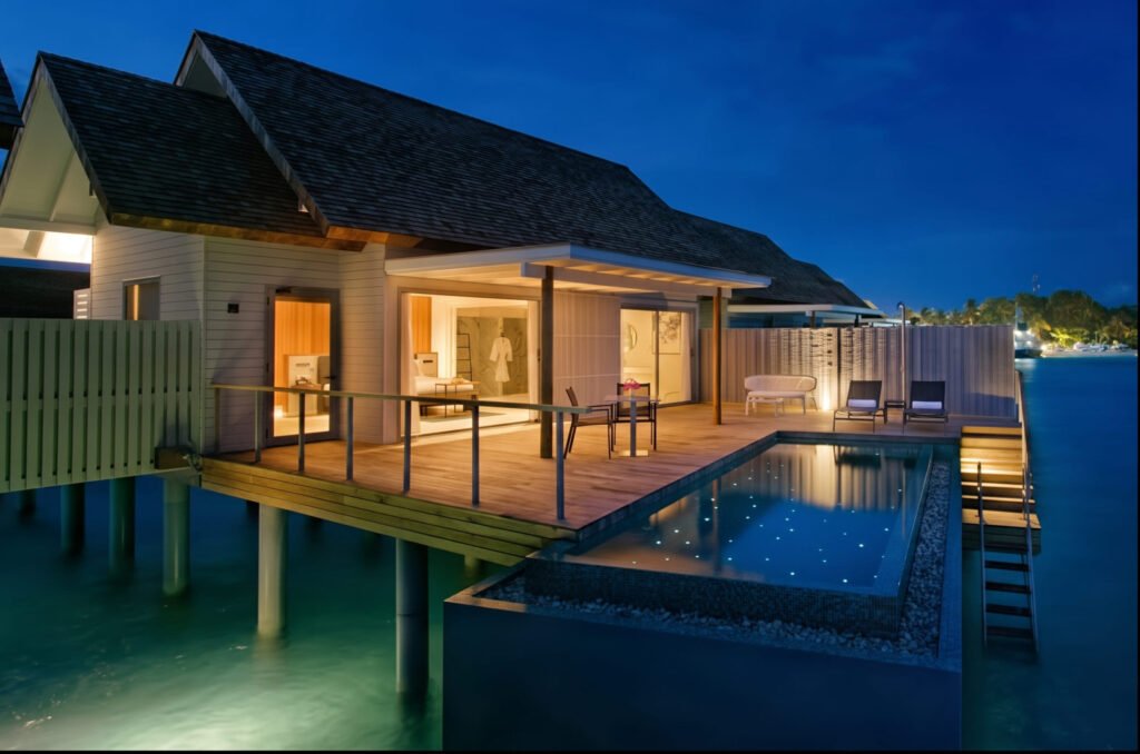 Luxury overwater villa with private pool and ocean view at a Visa on arrival Country Maldives resort at dusk.